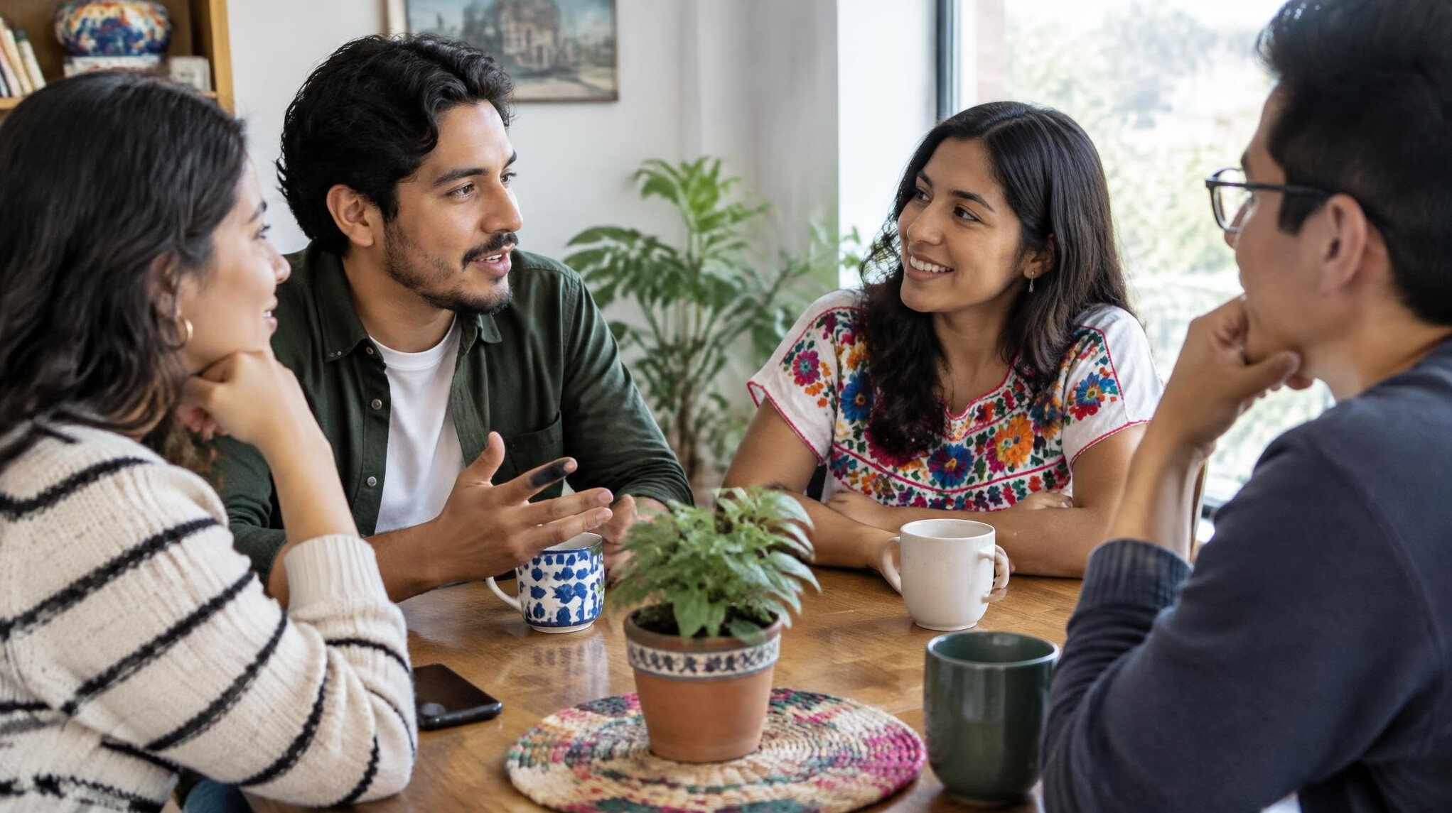 Group of friends talking around a table in a bright room