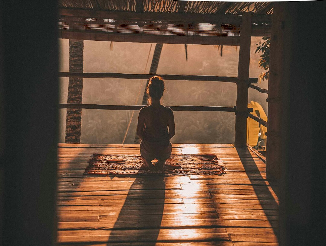 person meditating in morning light