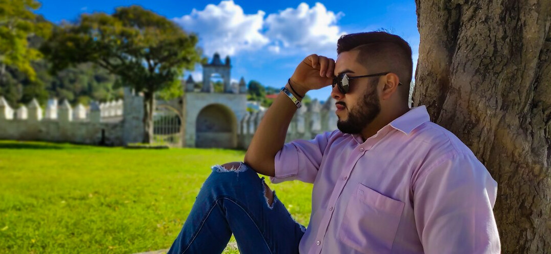 Portrait of a Mexican man in glasses wearing a light blue shirt